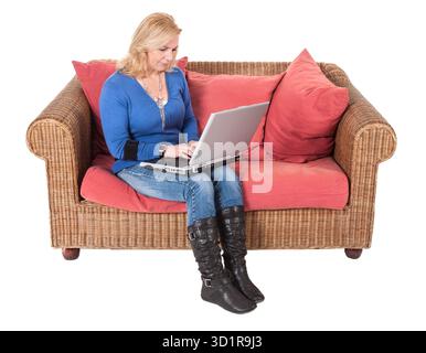 Frau, die mit Laptop arbeitet, sitzt auf einer Bank Stockfoto
