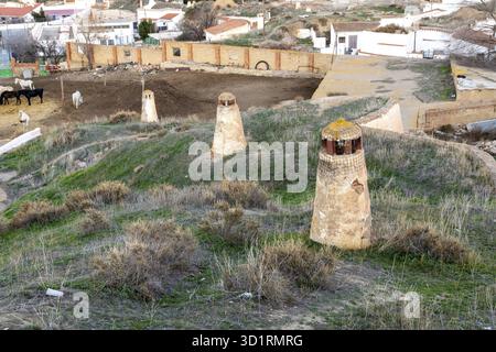 Guadix, Granada - Spanien - 24.01.2024: Höhlenhäuser in Guadix, mit mehreren Lüftungsschornsteinen, die typisch für die Architektur der Region sind, in die Erde gegraben Stockfoto
