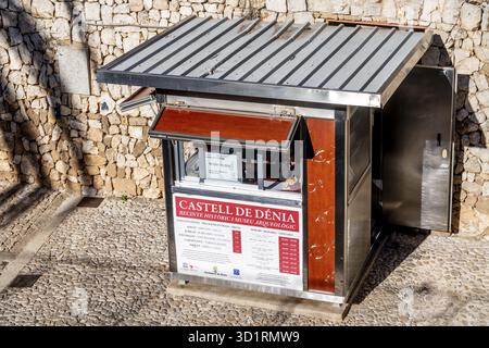 Denia, Alicante - Spanien - 12-22-2023: Ticketschalter für Castell de Denia vor einer Pflastermauer mit Eintrittsgeldern und Zeitplänen Stockfoto