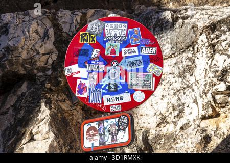 Denia, Alicante - Spanien - 22.12.2023: Straßenschild mit verschiedenen bunten Aufklebern, die ein Mosaik städtischer Kunst auf einer spanischen Straße schaffen Stockfoto