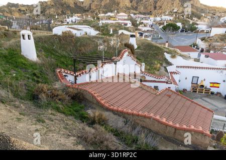 Guadix, Granada - Spanien - 24.01.2024: Ein Blick auf traditionelle Höhlenhäuser in Guadix, mit Dächern und weißen Kaminen, die von der Erde ragen, mit einem sma Stockfoto