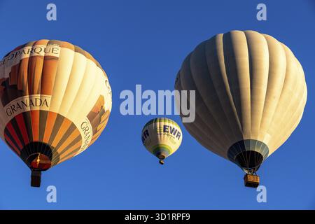 Guadix, Granada - Spanien - 24. 01.2024: Drei Heißluftballons steigen in den klaren blauen Himmel, darunter ein Ballon mit der Lesung Granada Geoparque Stockfoto