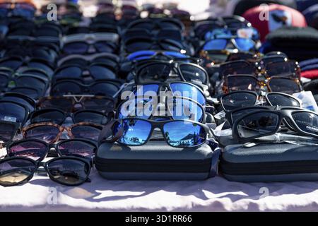 Guadix, Granada - Spanien - 24.01.2024: Eine Kollektion von Sonnenbrillen mit blauen und schwarzen Gläsern, Reflexionen der Umgebung auf einigen Gläsern, d Stockfoto