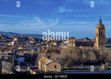 Guadix, Granada - Spanien - 24.01.2024: Ein malerischer Blick auf Guadix mit einem hohen Kirchturm und historischen Gebäuden unter einem klaren blauen Himmel mit Au Stockfoto