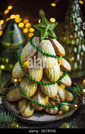 Weihnachtsbaum mit Weihnachtsdekor und Lichtern mit Madeleine Cookie Stockfoto