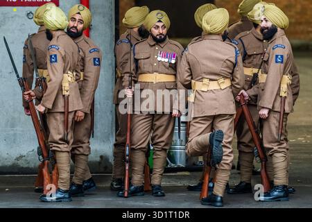 London, Großbritannien. Oktober 2025. Die 1914 Sikhs zeremonielle Marschtruppe bei nassem Wetter in Wellington Barracks, London. Unter der Leitung von Kapitän Daljinder Singh Virdee ist es eine neue Militärtruppe, die geschaffen wurde, um an die 100.000 Sikh-Soldaten zu erinnern, die im Ersten Weltkrieg für Großbritannien kämpften. Es ist eine Zusammenarbeit zwischen der Sikh Military Foundation und der British Army. Die Soldaten tragen echte Sikh-Infanterie-Uniformen aus dem Ersten Weltkrieg und tragen historische Ausrüstung wie Lee Enfield-Gewehre. Die meisten dienen Personal der Royal Navy, Army und RAF. Guy Bell/Alamy Live News Stockfoto