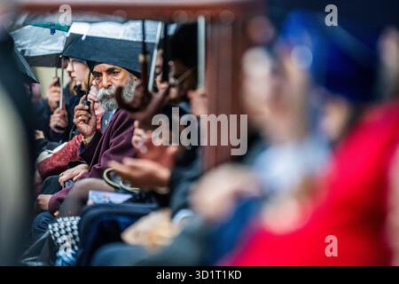 London, Großbritannien. Oktober 2025. Regenschirme sind für Veteranen in der Menge - die 1914 Sikhs zeremonielle Marschtruppe bei nassem Wetter in Wellington Barracks, London. Unter der Leitung von Kapitän Daljinder Singh Virdee ist es eine neue Militärtruppe, die geschaffen wurde, um an die 100.000 Sikh-Soldaten zu erinnern, die im Ersten Weltkrieg für Großbritannien kämpften. Es ist eine Zusammenarbeit zwischen der Sikh Military Foundation und der British Army. Die Soldaten tragen echte Sikh-Infanterie-Uniformen aus dem Ersten Weltkrieg und tragen historische Ausrüstung wie Lee Enfield-Gewehre. Die meisten dienen Personal der Royal Navy, Army und RAF. Guy Bell/Alamy Live Stockfoto