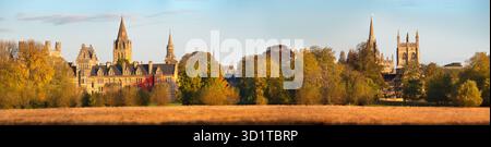 Panoramablick auf Oxford Wahrzeichen von Christ Church College Meadows an einem schönen Herbstmorgen. Es gibt so viele großartige Sehenswürdigkeiten von Oxford in dieser Aufnahme, einschließlich – von links nach rechts – Tom Tower, Christ Church College und Kathedrale, All Saints und St Mary's Church, Merton Chapel und (teilweise versteckt) die Kuppel von Radcliffe Camera. Stockfoto