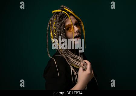 Frau mit Dreadlocks, die vor grünem Hintergrund stehen Stockfoto