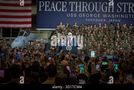 Yokosuka, Japan. Oktober 2025. US-Präsident Donald Trump, Mitte, zusammen mit dem japanischen Premierminister Sanae Takaichi, links, hält Anmerkungen an Seeleute und Marines in der Hangarbucht des Flugzeugträgers USS George Washington, die in der Nimitz-Klasse auf der Flottenaktivitäten Yokosuka, 28. Oktober 2025, in Yokosuka, Japan. Quelle: MC2 Bruce Morgan/US Navy Photo/Alamy Live News Stockfoto