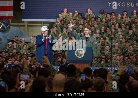 Yokosuka, Japan. Oktober 2025. US-Präsident Donald Trump, links, applaudiert Marineflugzeuge der 3. Klasse James McCall, Mitte, in der Hangarbucht des Flugzeugträgers USS George Washington, der Nimitz-Klasse, legte pierside bei Fleet Activities Yokosuka an, 28. Oktober 2025 in Yokosuka, Japan. Quelle: MC2 Bruce Morgan/US Navy Photo/Alamy Live News Stockfoto