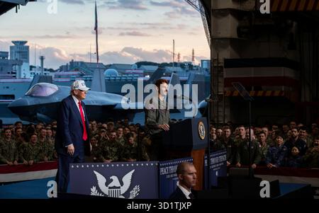 Yokosuka, Japan. Oktober 2025. US-Präsident Donald Trump, links, wird von Marineflugzeuge der 3. Klasse James McCall, rechts vorgestellt, bevor er den Seeleuten und Marines in der Hangarbucht des Flugzeugträgers USS George Washington, der Nimitz-Klasse, die pierside bei Fleet Activities Yokosuka, 28. Oktober 2025 in Yokosuka, Japan, vorbrachte. Foto: MCS Roselia Garcia/US Navy Photo/Alamy Live News Stockfoto