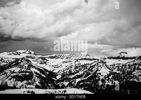 Schwarzweiß-Foto von schneebedeckten Gipfeln in der Grand Teton Mountain Range in Wyoming, USA, mit dramatischen Sturmwolken. Stockfoto