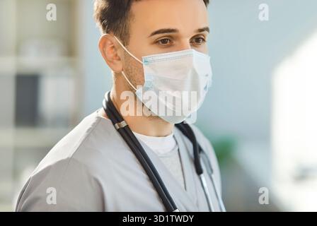 Arzt, männliche Krankenschwester Arzt sucht, trägt Gesichtsmaske und Stethoskop in der Klinik Stockfoto