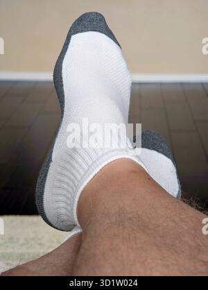 Nahaufnahme von Menschenfüßen, die sich beim Entspannen kreuzten Stockfoto