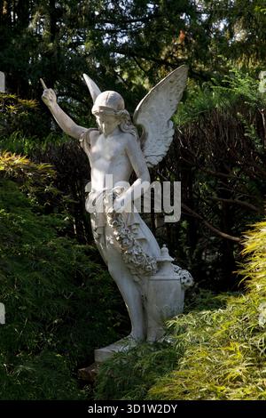 Engelsfigur auf einem Grabstein umgeben von grüner Natur, Alter Friedhof, Bonn, Deutschland, Europa Stockfoto