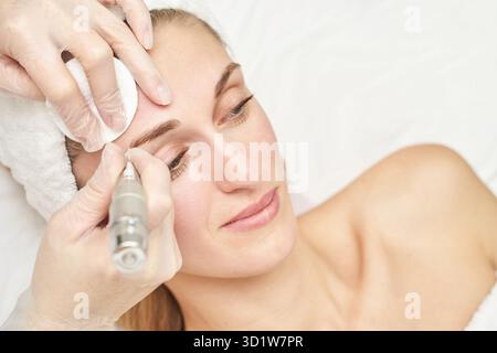 Dauerhaftes Make-up. Schönheitskurprozedur. Junge Frau. Gesichtstattoo Stockfoto