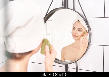 Eine junge Frau, die die Morgenroutine macht. Die Geburtsbehandlung im Bad. Gesundheitswesen Stockfoto