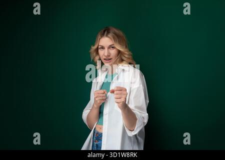 Frau, die vor der grünen Mauer steht Stockfoto