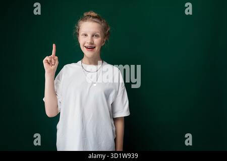 Frau in weißem T-Shirt zeigt auf die Kamera Stockfoto