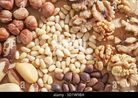 Viele verschiedene Muttern. Auswahl gesunder Snacks. Mediterrane Ernährung. Trockene vegane Wurstwaren. Partyhaufen in verschiedenen Variationen. Küchentisch. Fettnährstoffe Stockfoto