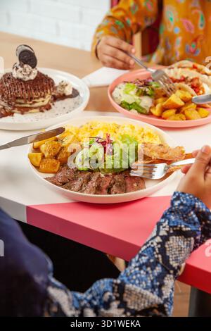 Arabische Frau genießt Brunch Steak und Ei mit Freunden in einem Restaurant. Stockfoto