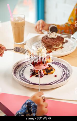 Weibchen beim Brunch Desserts Eis Waffeln und Pfannkuchen. Stockfoto