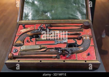Ein Paar antiker Duellpistolen von Jean Le Page, offen in einem passenden Holzkoffer mit rotem Samtfutter ausgestellt, wahrscheinlich in einer Museumssammlung. Amste Stockfoto