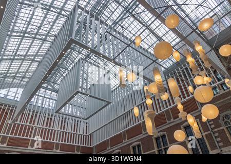 Die atemberaubende, lichtdurchflutete Eingangshalle des Rijksmuseums in Amsterdam mit einem großen Glasdach und einer Reihe von Laternen aus Papier. A Stockfoto
