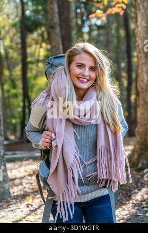 Der blonde Entdecker erfreute sich in „Herbstliche Schönheit: Eine Reise durch den Goldenen Wald und fallende Blätter“ Stockfoto