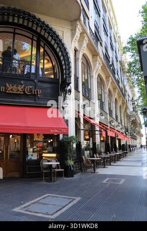 Eine Straße in Buenos Aires mit einem Café im englischen Stil mit markanten roten Markisen. Die Passanten werden eingeladen, eine Pause einzulegen. Stockfoto