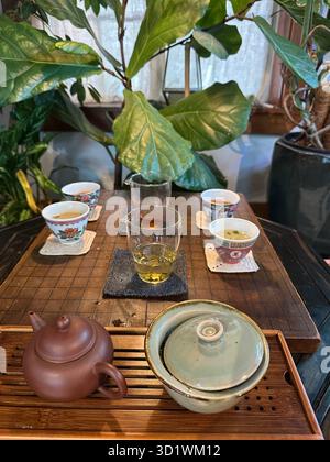 Tassen, Gläser und Teekannen auf einem Tisch während einer Teeverkostung. Stockfoto