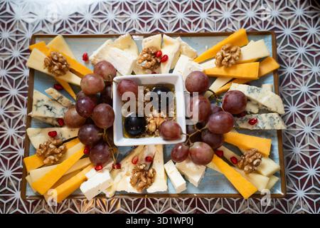 Käseplatte mit Trauben und Walnüssen Stockfoto
