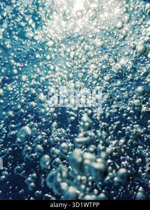 Luftblasen unter Wasser mit Sonnenlicht Stockfoto