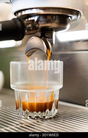 Frischer Espresso, der ins Glas gegossen wird Stockfoto