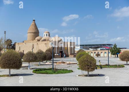 Buchara, Usbekistan - 27. März 2024: Straßenblick mit Touristen in der Nähe des Chashma-Ayub Mausoleums. Der älteste Teil des Objekts stammt aus dem 12. Jahrhundert Stockfoto