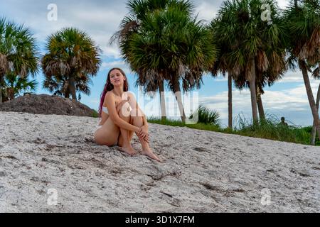 Sonnenverwöhnte Ruhe: Strahlende Schönheit entspannt sich stilvoll am Strand Stockfoto