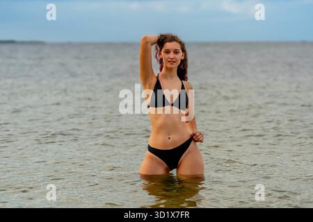Sonnenverwöhnte Ruhe: Strahlende Schönheit entspannt sich stilvoll am Strand Stockfoto