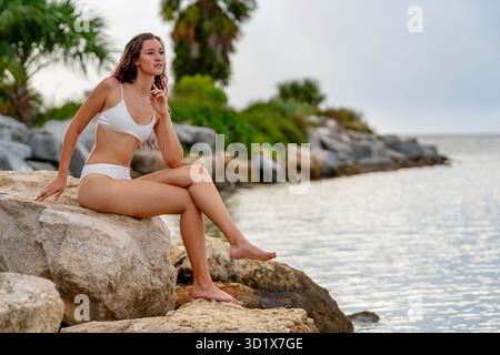 Sonnenverwöhnte Ruhe: Strahlende Schönheit entspannt sich stilvoll am Strand Stockfoto