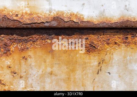 Verwitterte lackierte Metalloberfläche mit Roststreifen. Stockfoto