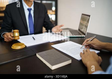 Rechtsberater präsentiert auf dem Client einen unterzeichneten Vertrag mit Hammer und rechtlichen Gesetz. Justiz und Rechtsanwalt Konzept Stockfoto