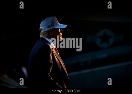 Yokosuka, Japan. Oktober 2025. US-Präsident Donald Trump geht auf die Bühne, um Seeleute und Marines in der Hangarbucht des Flugzeugträgers USS George Washington der Nimitz-Klasse bei Fleet Activities Yokosuka, 28. Oktober 2025 in Yokosuka, Japan, zu sprechen. Quelle: Daniel Torok/White House Photo/Alamy Live News Stockfoto