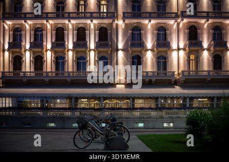 Klassische Fahrräder parken vor dem gut beleuchteten Hotel in Viareggio, Italien Stockfoto