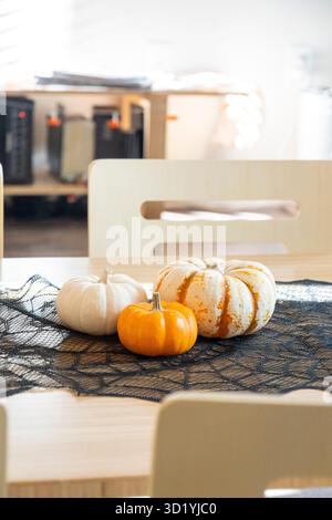 Gemütliche Herbstdesszene mit Kürbissen, rustikaler Küche mit Kürbissen und Spitze der Saison Stockfoto
