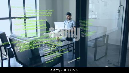 Arbeitender indischer Softwareentwickler, der auf einem Laptop auf dem Sofa in der Bürolounge mit Codereflektionen codiert Stockfoto