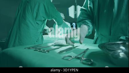 Die Hand des Chirurgen mit Handschuhen erreichen, Skalpell auf einem drapierten Tablett unter Licht im Operationssaal auswählen Stockfoto