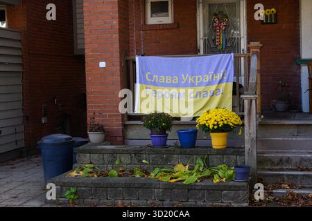 Toronto, ON, Kanada - 24. Oktober 2025: Eine kanadische Flagge und eine ukrainische Flagge hängen auf der Veranda eines Backsteinhauses. Stockfoto