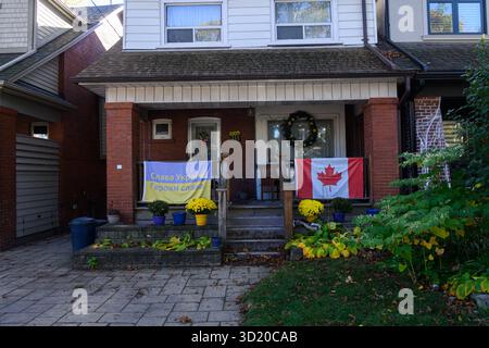Toronto, ON, Kanada - 24. Oktober 2025: Eine kanadische Flagge und eine ukrainische Flagge hängen auf der Veranda eines Backsteinhauses. Stockfoto