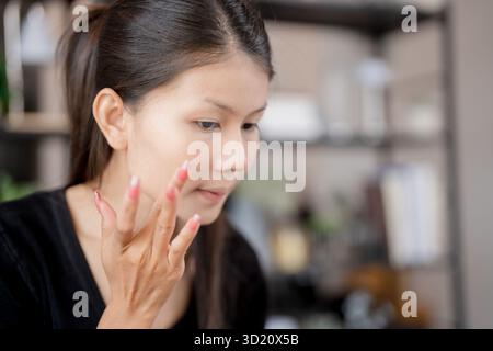 Asiatische Frau, die Make-up Foundation und Concealer Make-up auf Gesicht mit Kosmetik Makeover täglicher Schönheit Routine zu Hause. Stockfoto