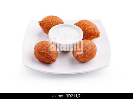 Knusprige goldene Krapfen serviert mit kühler Joghurtsauce auf einer Platte während einer festlichen Versammlung Stockfoto